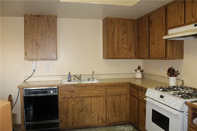 a kitchen with a stove sink and cabinets