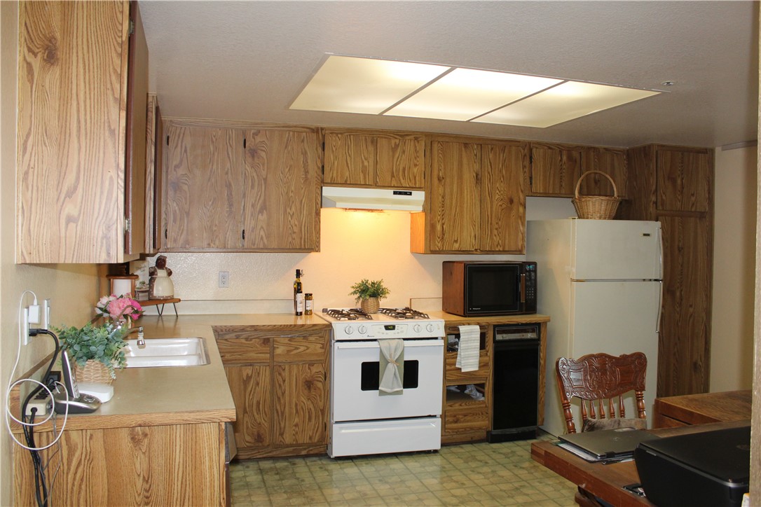 12141 Centralia Street, Unit 119 Lakewood, CA 90715 - Photo 8 of 31 a kitchen with a stove a refrigerator and a sink