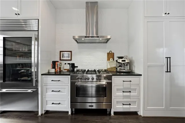 a kitchen with granite countertop a sink cabinets and stainless steel appliances