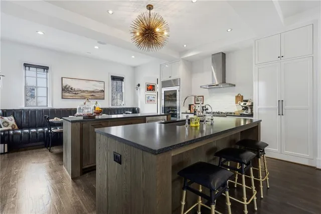 a kitchen with stainless steel appliances granite countertop a sink and a living room