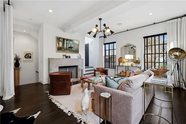 a living room with furniture two window and wooden floor