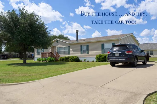 a front view of a house with a garden and parking