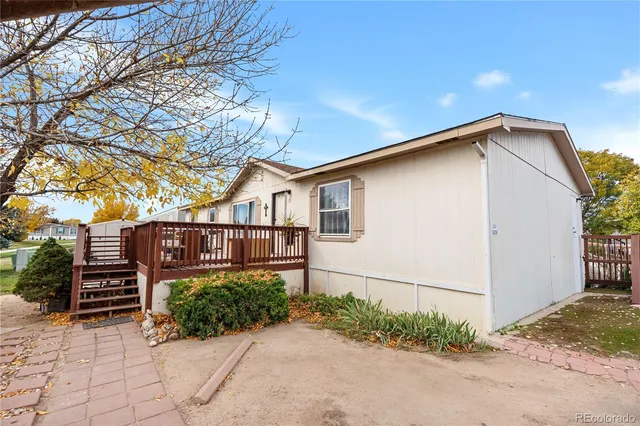 a view of a house with wooden fence next to a road