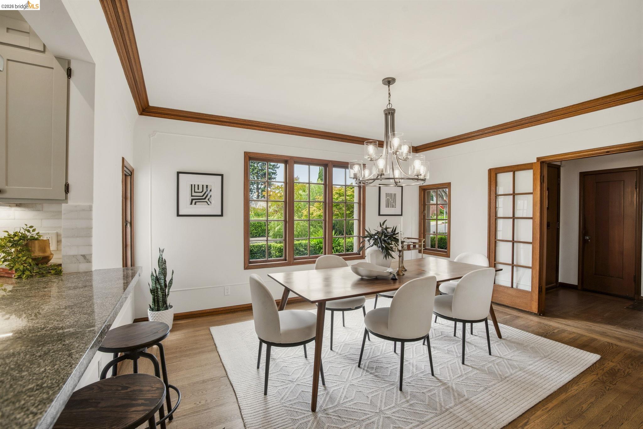 1087 Hubert Road Oakland, CA 94610 - Photo 9 of 67 Dining space featuring a multi-pane window, wood-finish flooring, and a chandelier light fixture