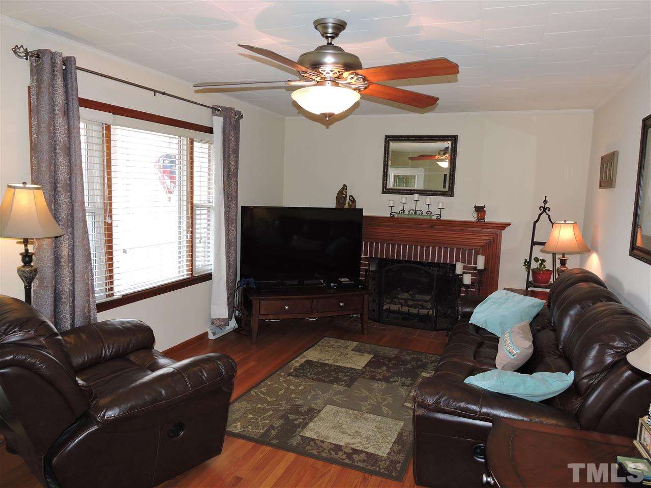 505 Robertson Road Roxboro, NC 27574 - Photo 2 of 16 a living room with furniture a fireplace and a flat screen tv