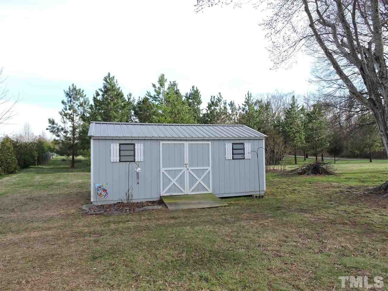 505 Robertson Road Roxboro, NC 27574 - Photo 16 of 16 a view of a barn in the yard with large trees