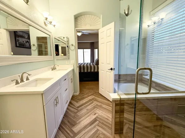 a spacious bathroom with a double vanity sink a mirror and shower