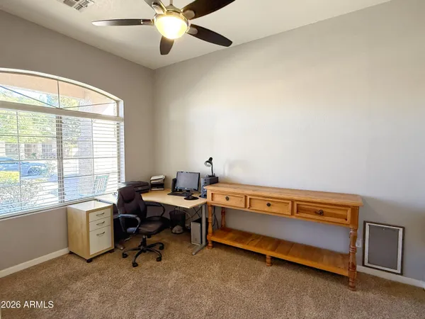 a view of a workspace with furniture and a window