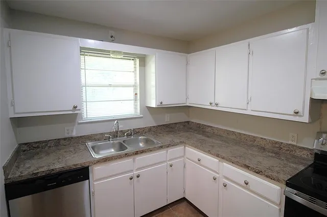 a kitchen with granite countertop white cabinets and a sink