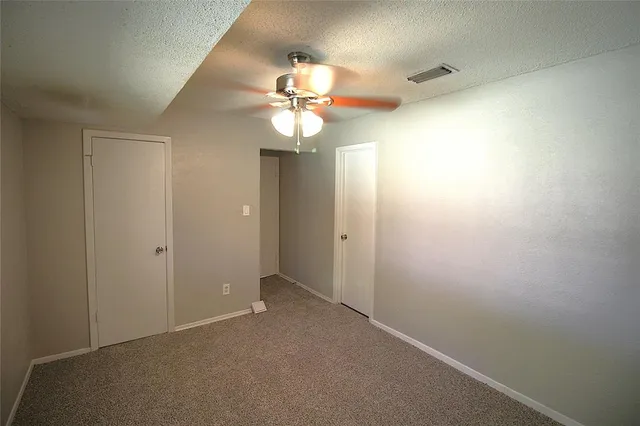 en empty room with windows and fan