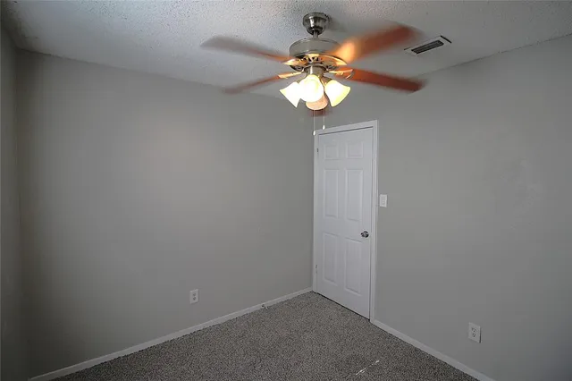 an empty room with a chandelier fan and a chandelier fan