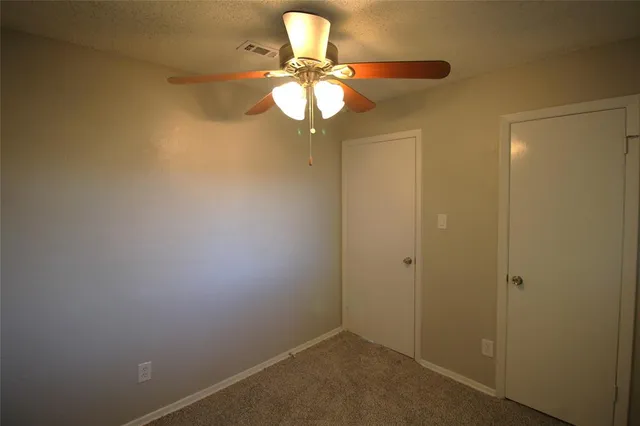 a view of room with chandelier fan and window