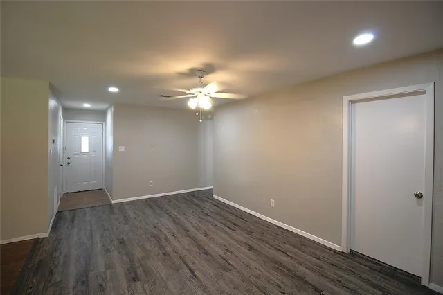 an empty room with wooden floor and mirror