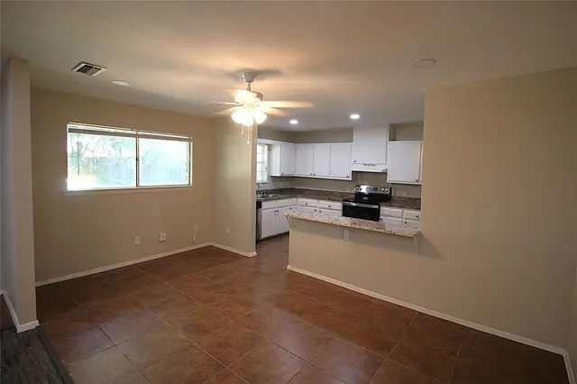 a view of kitchen with kitchen island stainless steel appliances a sink and a stove