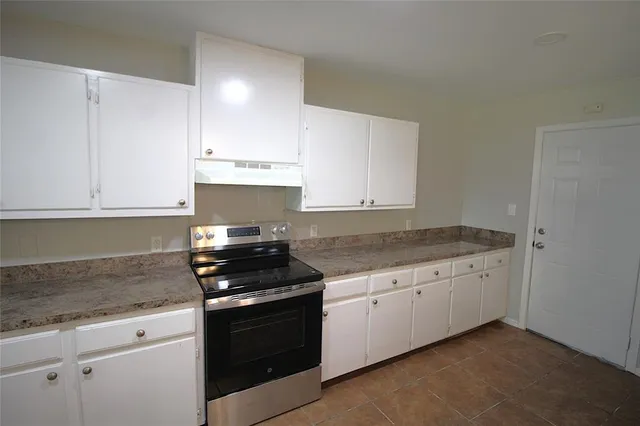 a kitchen with granite countertop white cabinets and appliances