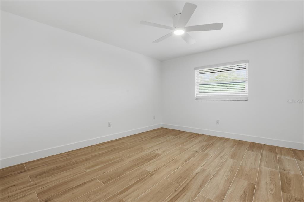 4460 Oakley Street Punta Gorda, FL 33980 - Photo 9 of 18 an empty room with wooden floor and windows
