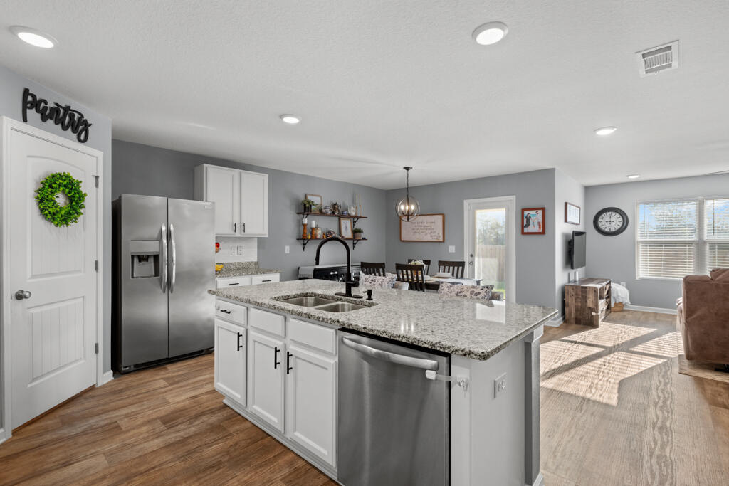 969 Merganser Way Crestview, FL 32539 - Photo 17 of 44 a kitchen with stainless steel appliances granite countertop a sink stove and refrigerator