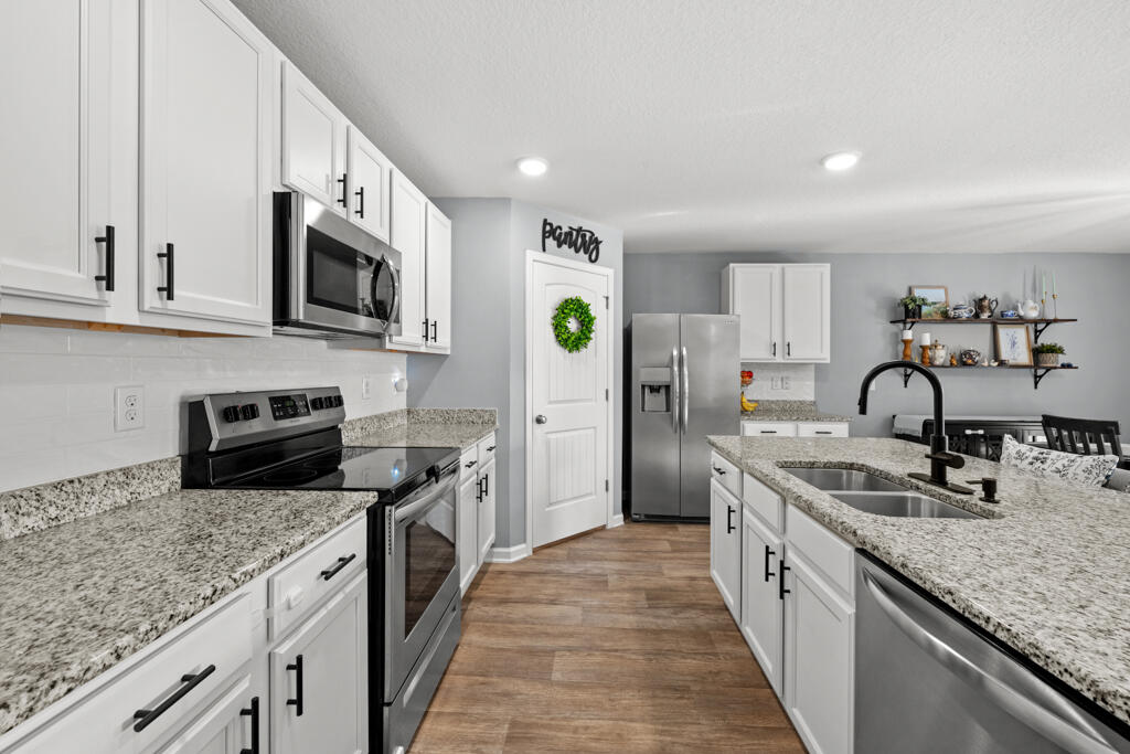 969 Merganser Way Crestview, FL 32539 - Photo 18 of 44 a kitchen with stainless steel appliances granite countertop a sink stove and refrigerator