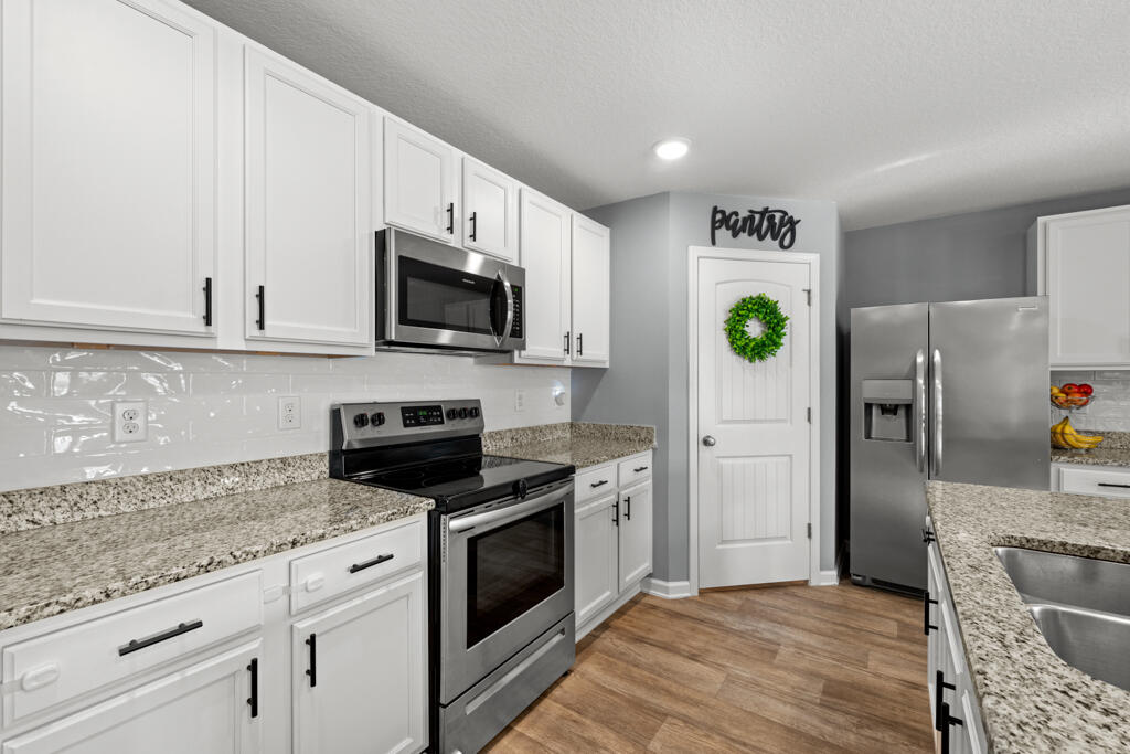 969 Merganser Way Crestview, FL 32539 - Photo 19 of 44 a kitchen with stainless steel appliances granite countertop a stove a refrigerator and a microwave
