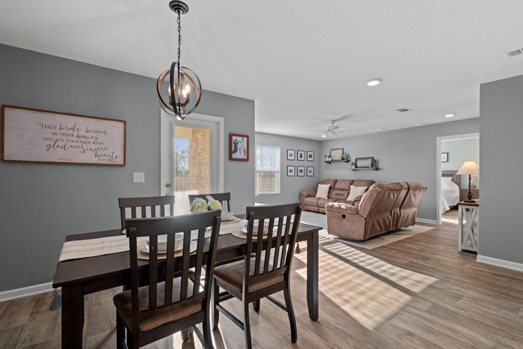 969 Merganser Way Crestview, FL 32539 - Photo 23 of 44 a view of a dining room with furniture wooden floor and a chandelier