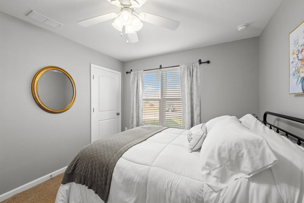 969 Merganser Way Crestview, FL 32539 - Photo 7 of 44 a bedroom with a bed and a chandelier