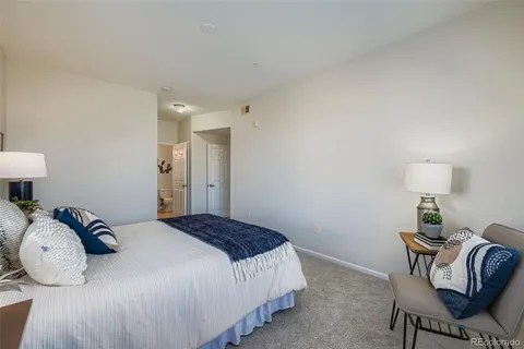 a bedroom with bed and a lamp on table