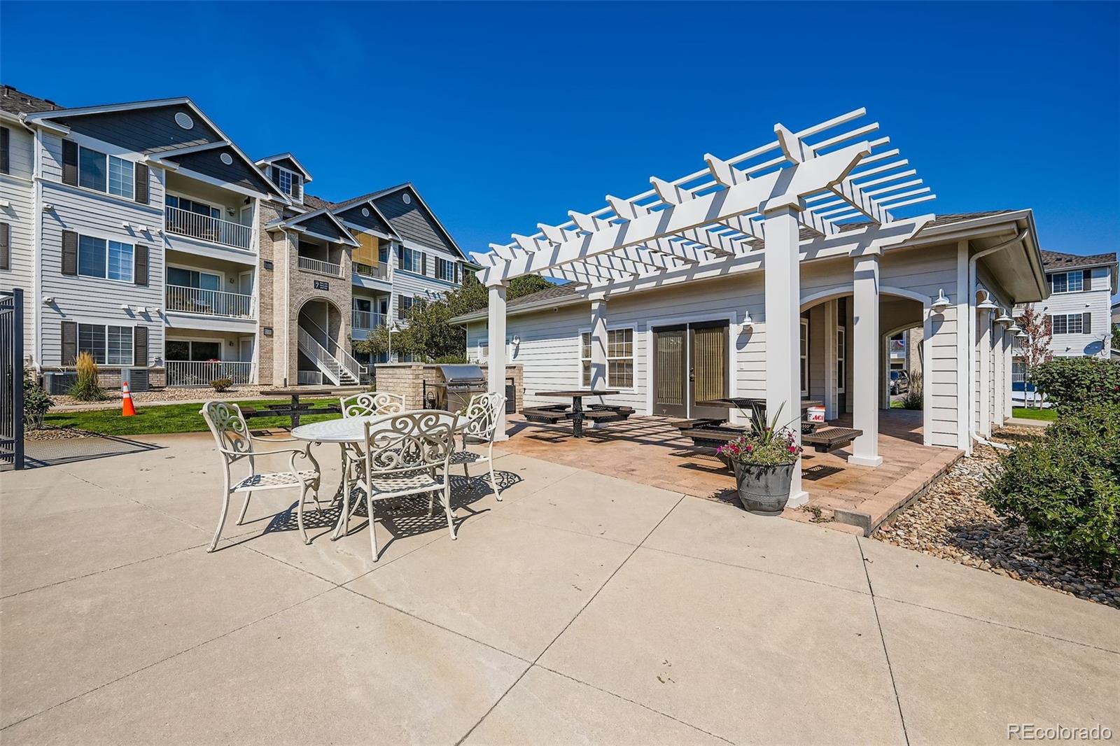 15700 East Jamison Drive, Unit 7101 Englewood, CO 80112 - Photo 28 of 31 a view of a patio with dining table and chairs with plants and a barbeque