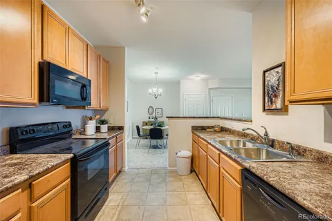 a kitchen with a sink stove top oven and refrigerator