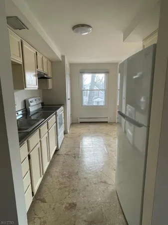 a kitchen with granite countertop white cabinets and white stainless steel appliances