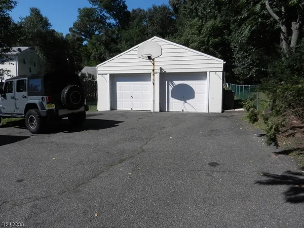 a view of a house with a yard and parking space