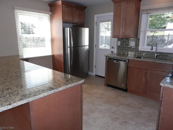 a kitchen with stainless steel appliances granite countertop a refrigerator a sink a stove a microwave a counter and cabinets