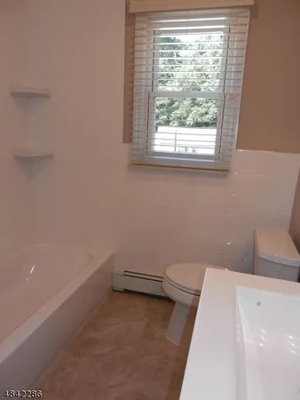 a bathroom with a toilet a sink and window