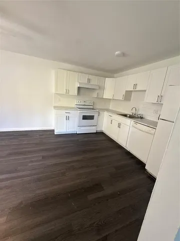 a kitchen with stainless steel appliances wooden floors and view living room