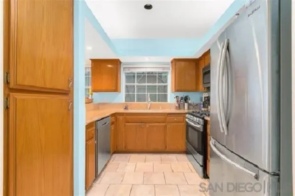 a kitchen with stainless steel appliances granite countertop a refrigerator and a sink