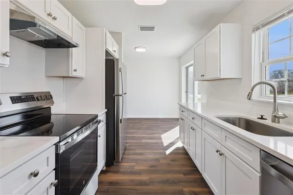 a kitchen with a sink stove and cabinets