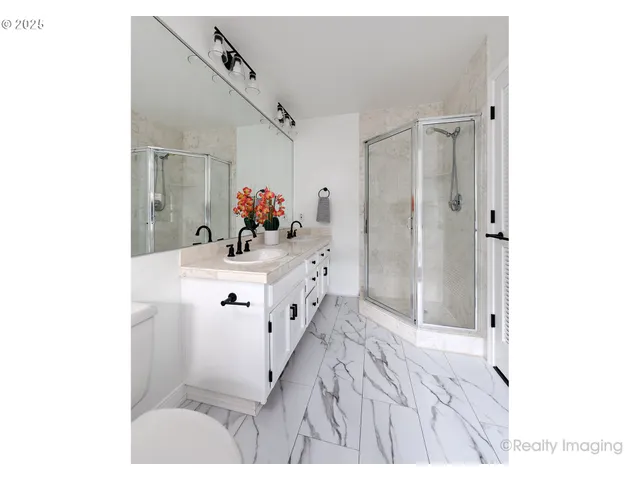 a bathroom with a sink mirror and shower