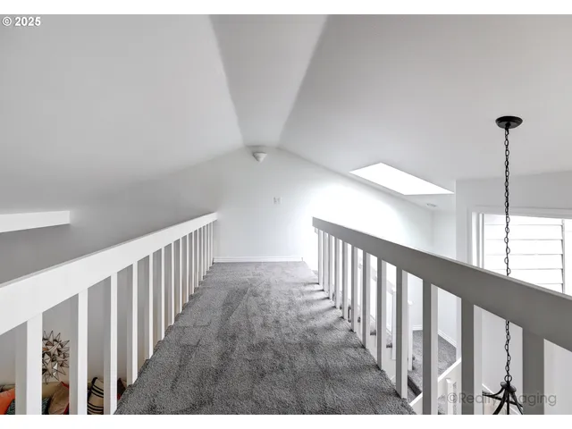 a view of staircase with railing and white walls