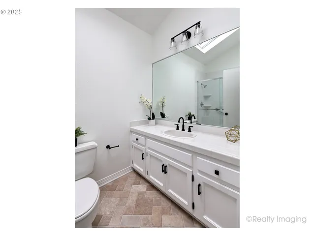 a bathroom with a double vanity sink toilet and mirror