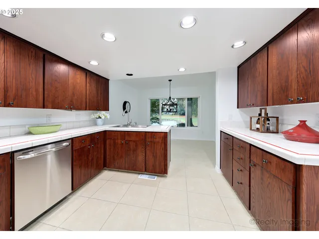 a kitchen with a sink a stove cabinets and a window