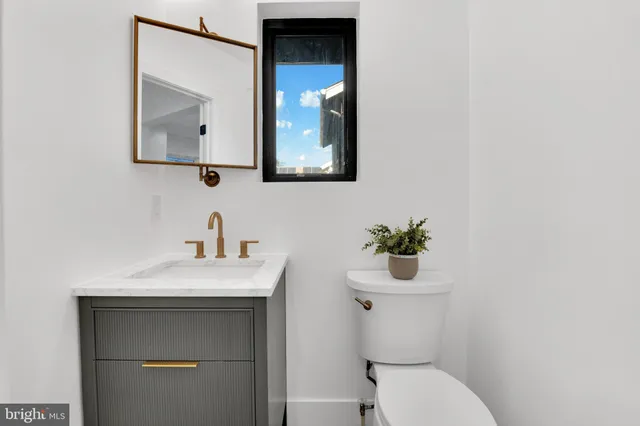 a bathroom with a toilet sink and mirror