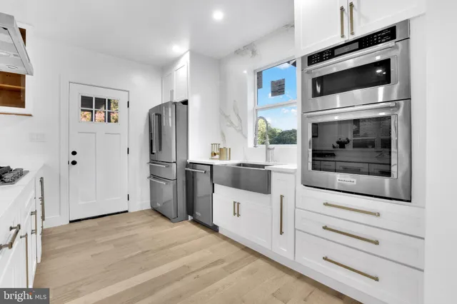 a kitchen with stainless steel appliances a refrigerator stove and cabinets