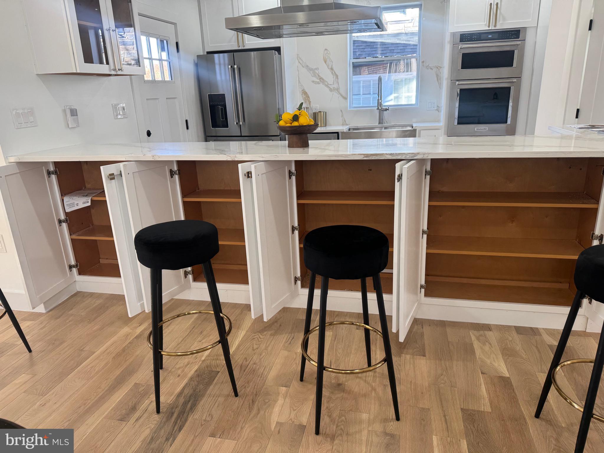 1312 Franklin Street Northeast Washington, DC 20017 - Photo 17 of 42 a kitchen with stainless steel appliances kitchen island a table chairs in it and wooden floors