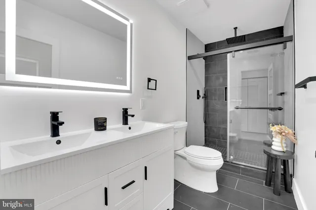 a bathroom with a sink toilet a mirror and shower