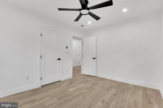 a view of a room with wooden floor and ceiling fan