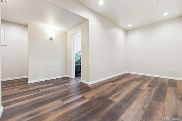 a view of an empty room with wooden floor