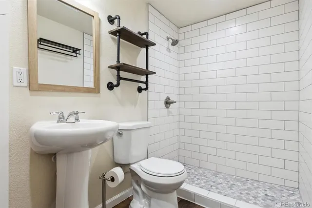 a bathroom with a sink a toilet and mirror