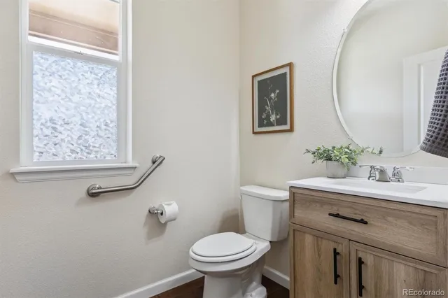 a bathroom with a toilet a sink and mirror