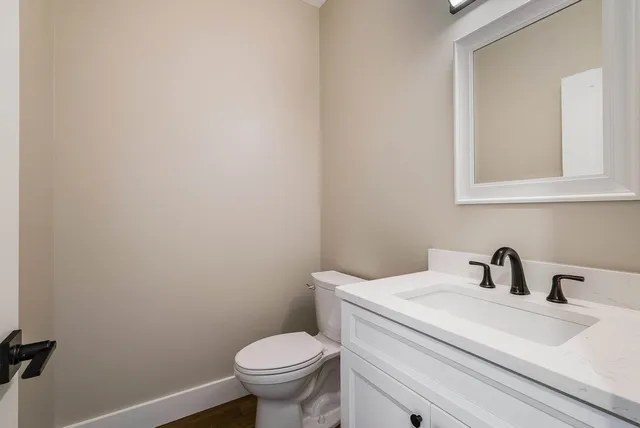 a bathroom with a toilet a sink and mirror