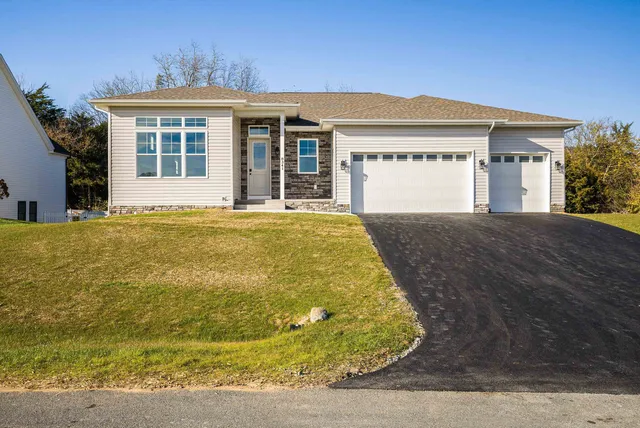 a large white kitchen with kitchen island a sink wooden floor and stainless steel appliances