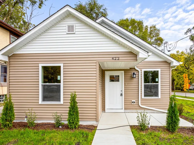 a view of a white house next to a yard